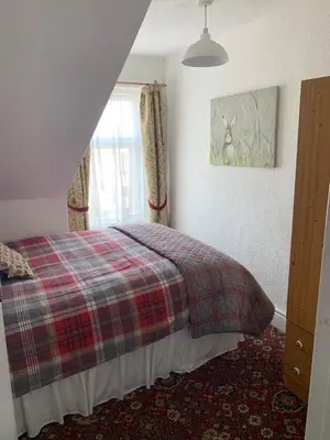 a bedroom with a bed and a window at Sarnia holiday flats in Blackpool