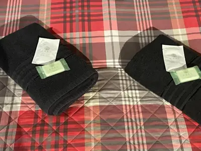 two black towels sitting on top of a bed at Sarnia holiday flats in Blackpool