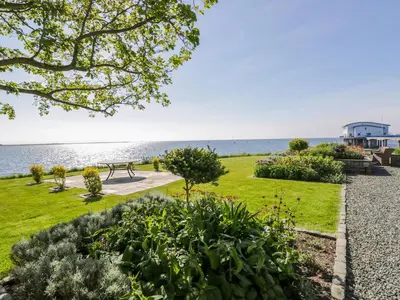 a park with a bench and the ocean in the background at Villa Marina in Barrow in Furness