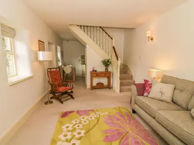 a living room with a couch and a chair at Spens Farm Cottage in Lancaster