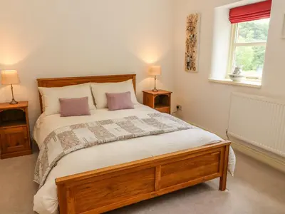 a bedroom with a large wooden bed with two lamps at Spens Farm Cottage in Lancaster