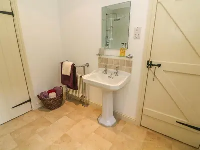 a bathroom with a sink and a mirror at Spens Farm Cottage in Lancaster