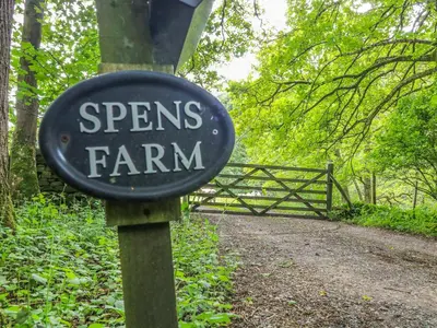 a sign that sayspes farm in front of a trail at Spens Farm Cottage in Lancaster