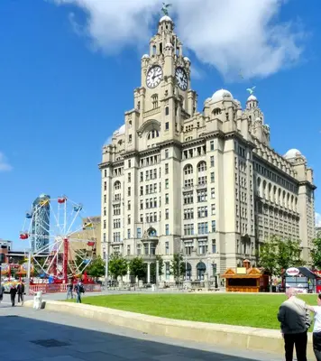 a large building with a clock tower on top of it at Cosy Anfield Guesthouse - Close to Stadium & City in Liverpool