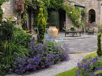 a bench sitting in a garden with purple flowers at Whitmore in Lancaster