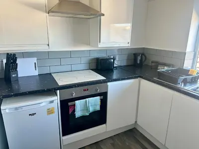 a kitchen with white cabinets and a stove top oven at Blackpool Tower Apartments by Blackpool Service Aparttments in Blackpool