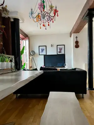 a living room with a black couch and a laptop at 2 Bed Duplex Penthouse Apartment by Mathew Street Sleeps 6 in Liverpool