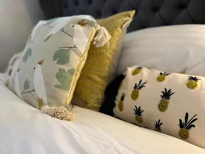 a bed with two pillows and a pillow with pineapples at 2 Bed Duplex Penthouse Apartment by Mathew Street Sleeps 6 in Liverpool