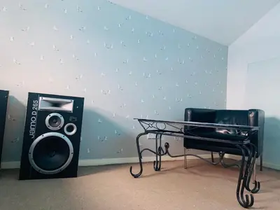 a room with a table and a speaker and a chair at 2 Bed Duplex Penthouse Apartment by Mathew Street Sleeps 6 in Liverpool