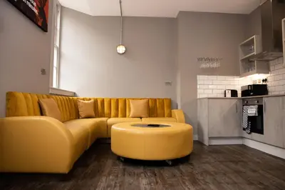 a living room with a yellow couch and a coffee table at York Street Studios in Liverpool