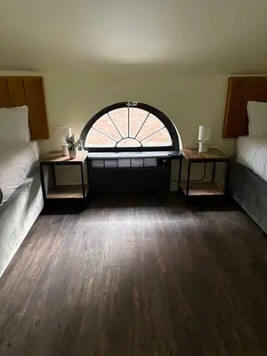 a room with two beds and a large window at York Street Studios in Liverpool