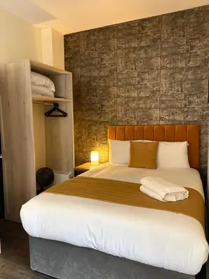 a bedroom with a large bed with a wooden headboard at York Street Studios in Liverpool