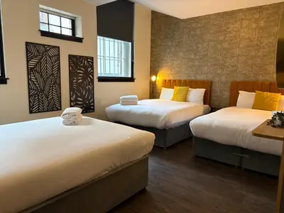 a hotel room with two beds and two windows at York Street Studios in Liverpool