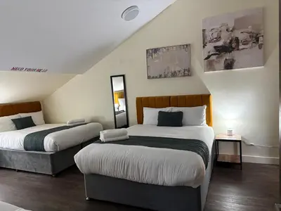 a hotel room with two beds and a mirror at York Street Studios in Liverpool