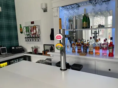 a bar with a counter with bottles of alcohol at North Crest in Blackpool