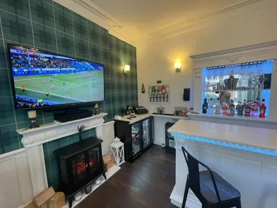 a living room with a tv and a fireplace with a television at North Crest in Blackpool