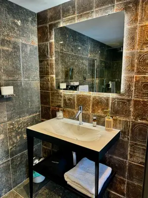 a bathroom with a sink and a large mirror at Quite Simply French in Lancaster