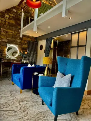 a living room with blue chairs and a table at Quite Simply French in Lancaster