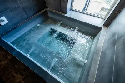 a bath tub filled with water in a bathroom at The Loft Sasco Apartments in Blackpool
