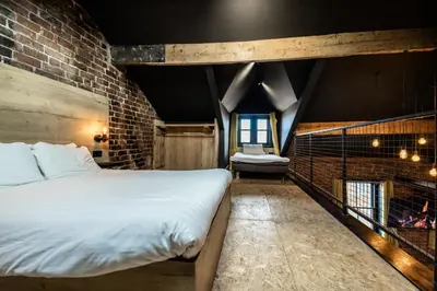 a bedroom with a large bed and a fireplace at The Loft Sasco Apartments in Blackpool