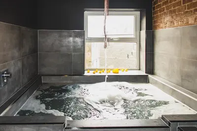 a bathroom with a bath tub with water in it at The Loft Sasco Apartments in Blackpool