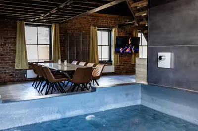 a dining room with a table and a swimming pool at The Loft Sasco Apartments in Blackpool