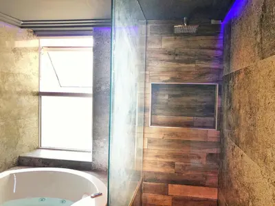 a bathroom with a tub and a wooden wall at The Residence Sasco Apartments in Blackpool