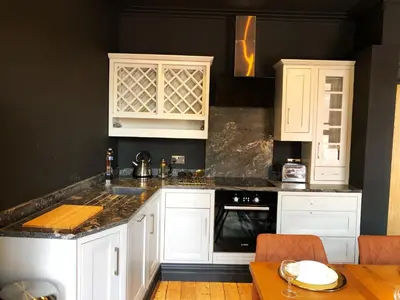 a kitchen with white cabinets and a black wall at The Residence Sasco Apartments in Blackpool