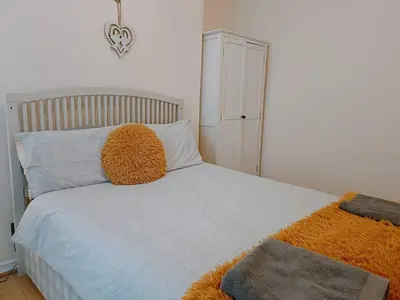 a bedroom with a bed with a orange pillow at Bright, Comfortable Home, Convenient for City Centre in Liverpool