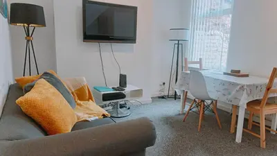 a living room with a couch and a table at Bright, Comfortable Home, Convenient for City Centre in Liverpool