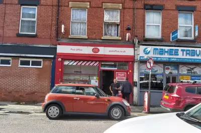 a small red car parked in front of a store at Bright, Comfortable Home, Convenient for City Centre in Liverpool