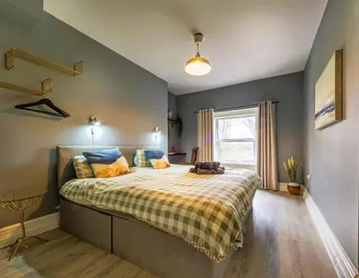 a bedroom with a large bed with a blanket on it at Botanic Rooms in Liverpool