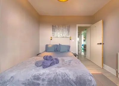 a bedroom with a large bed with purple towels on it at Botanic Rooms in Liverpool