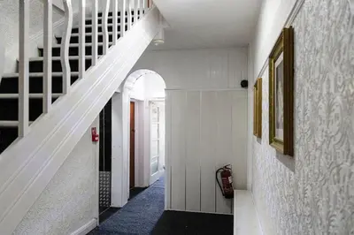 a hallway with a white staircase in a house at Harlands Hotel in Blackpool