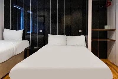 a bedroom with two white beds and a black wall at Harlands Hotel in Blackpool