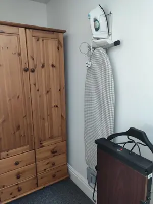 a room with a fan next to a wooden cabinet at Q Accommodation in Blackpool