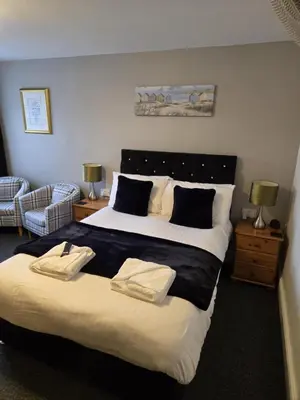 a bedroom with a large bed with two towels on it at Q Accommodation in Blackpool