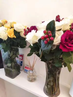 two vases filled with flowers on a shelf at Q Accommodation in Blackpool