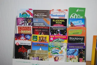a pile of books sitting on top of a shelf at Birch Villa in Blackpool