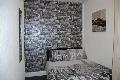a bedroom with a bed with a wall covered in photographs at Birch Villa in Blackpool