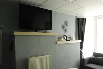 a living room with a flat screen tv on the wall at Birch Villa in Blackpool