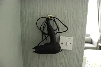 a black object hanging on a lightswitch on a wall at Birch Villa in Blackpool