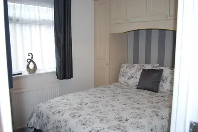 a white bedroom with a bed with a canopy at Birch Villa in Blackpool