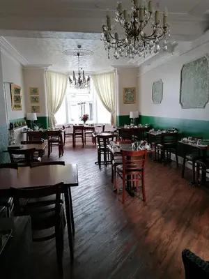 a dining room with tables and chairs and a chandelier at Birchhouse in Blackpool
