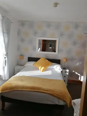 a bedroom with a bed with a yellow pillow on it at Birchhouse in Blackpool