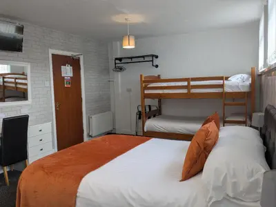 a bedroom with two bunk beds and a desk at Birchhouse in Blackpool