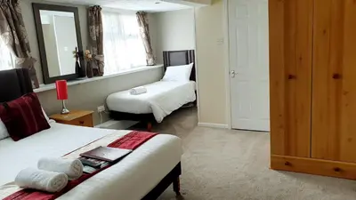 a hotel room with two beds and a mirror at Hilbre Hotel in Blackpool