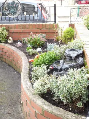 a garden with a fountain in a brick wall at Hilbre Hotel in Blackpool