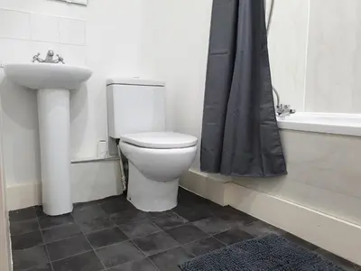 a bathroom with a toilet and a sink and a tub at Shandon Apt premium Liverpool City Centre in Liverpool