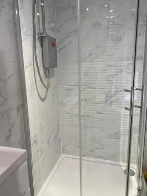 a shower with a glass door in a bathroom at Brownlows Inn Rooms formerly Riley's Rooms in Liverpool